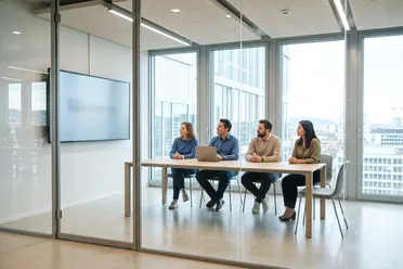 Team im hellen Besprechungsraum sieht das Ergebnis, das ein KI-Skill jedes Mal gleich liefert