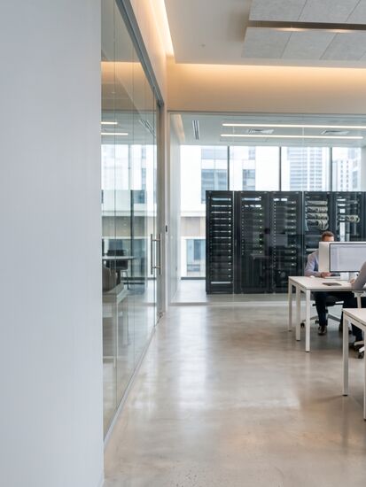 IT-Team im Besprechungsraum vor einer Netzarchitektur an der Wandtafel