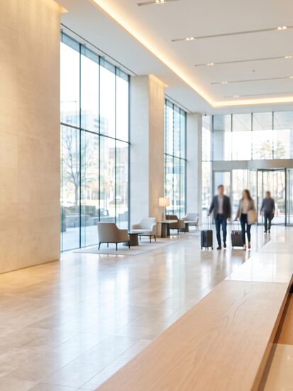 Empfangsmitarbeiterin mit Tablet in der Lobby eines großen Hotels