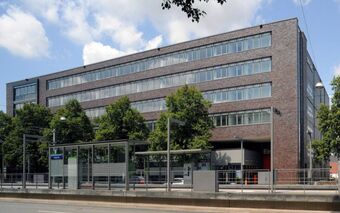 Das Bürogebäude der IFE GmbH in Hannover, ein modernes Gebäude mit mehreren Stockwerken und einem Busbahnhof vorne.