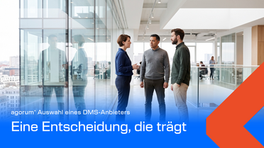 Drei Personen besprechen in einem hellen Bürogebäude die Auswahl eines DMS-Anbieters