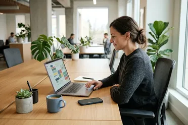 Mitarbeiterin prüft am Laptop Aufgaben und Termine, die aus einem Jour fixe entstanden sind